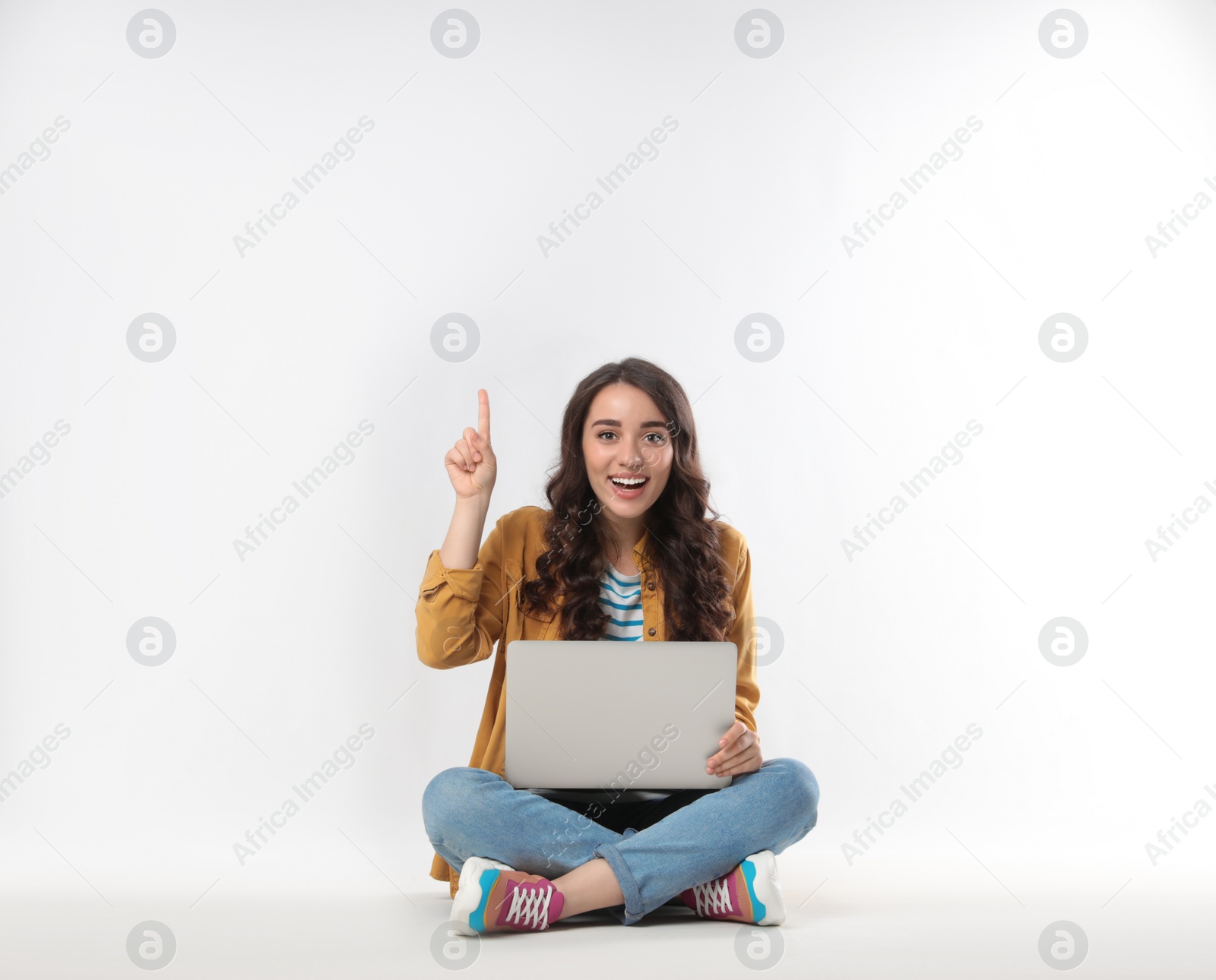 Photo of Young woman sitting with laptop on white background