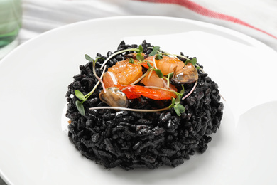 Photo of Delicious black risotto with seafood in plate, closeup