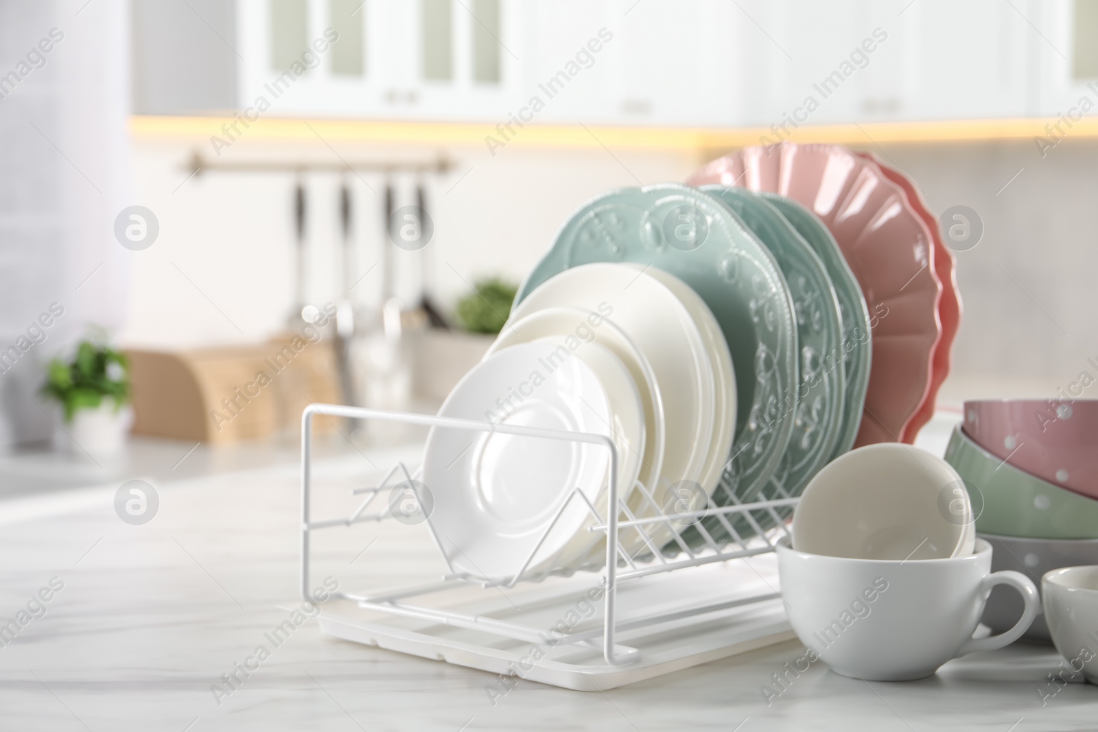 Photo of Many different clean dishware and cups on white marble table in kitchen. Space for text