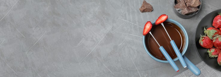 Image of Flat lay composition with chocolate fondue on grey table, space for text. Banner design