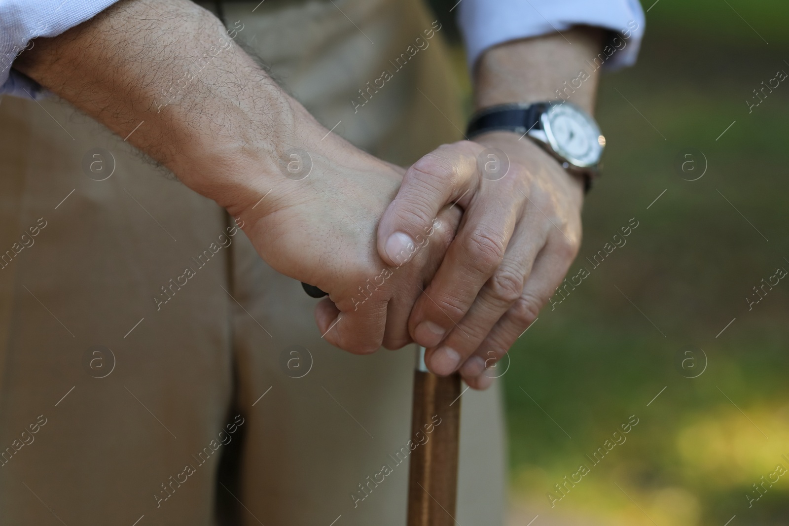 Photo of Senior man with walking cane outdoors, closeup