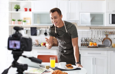 Photo of Food blogger recording video on camera in kitchen