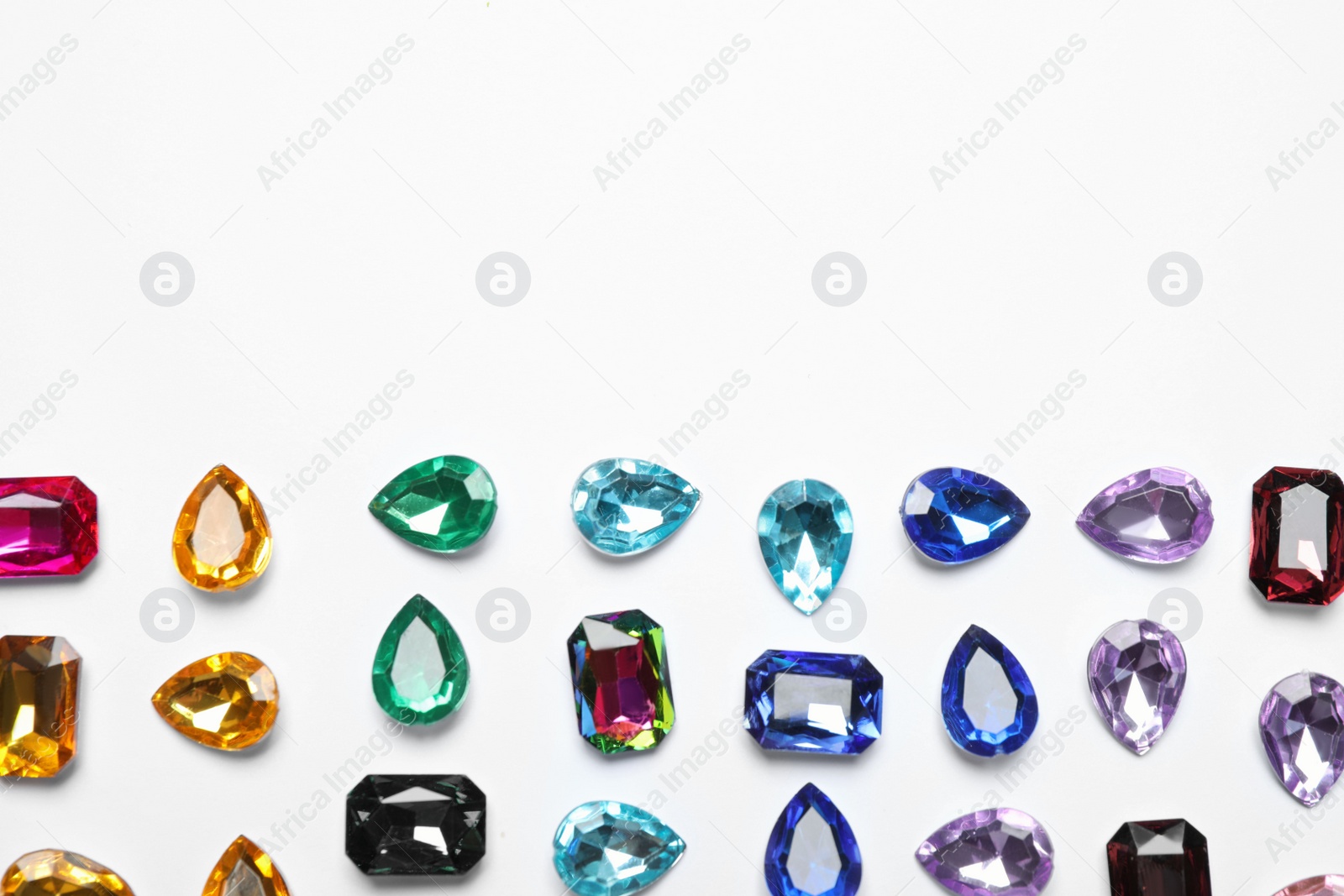 Photo of Different beautiful gemstones on white background, top view