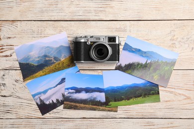 Photo of Vintage photo camera and beautiful printed pictures on wooden table, flat lay. Creative hobby