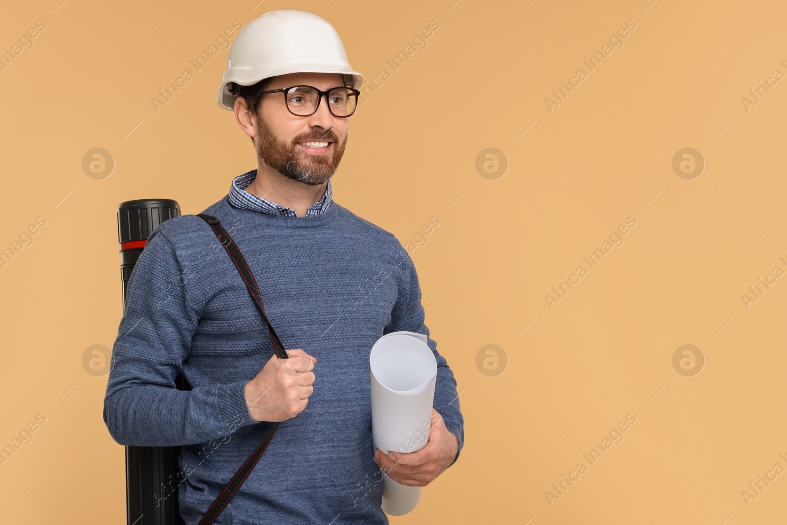 Photo of Architect in hard hat with drawing tube and draft on beige background, space for text