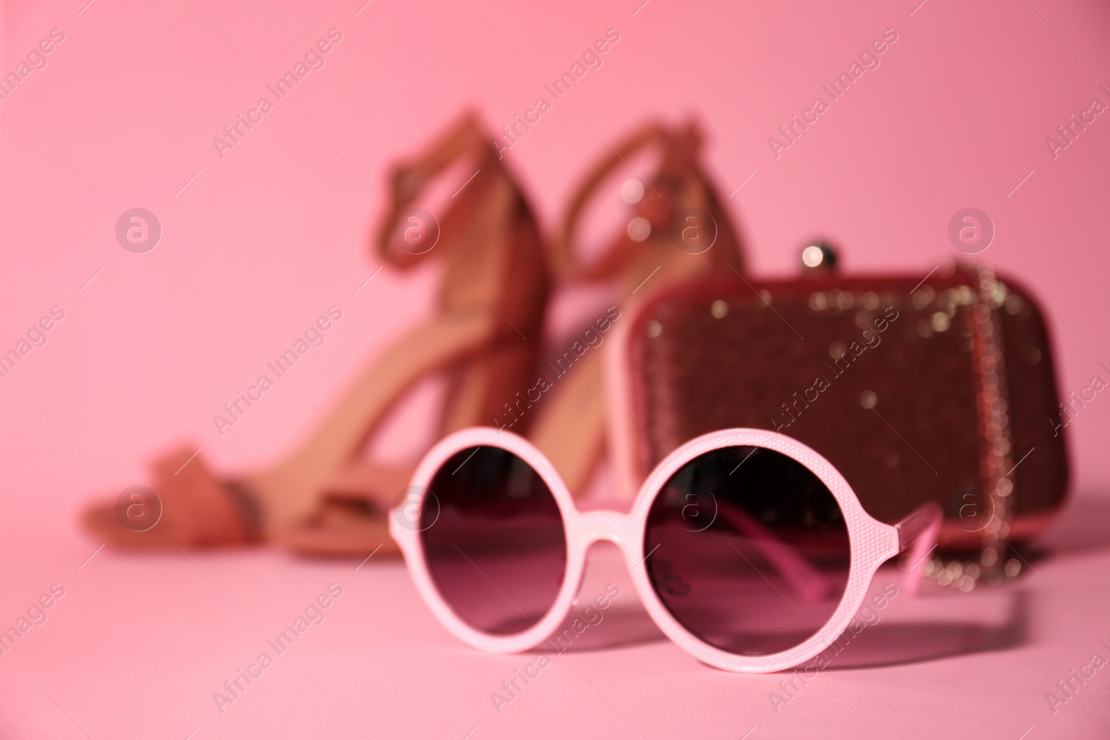 Photo of Stylish bright sunglasses on pink background, closeup