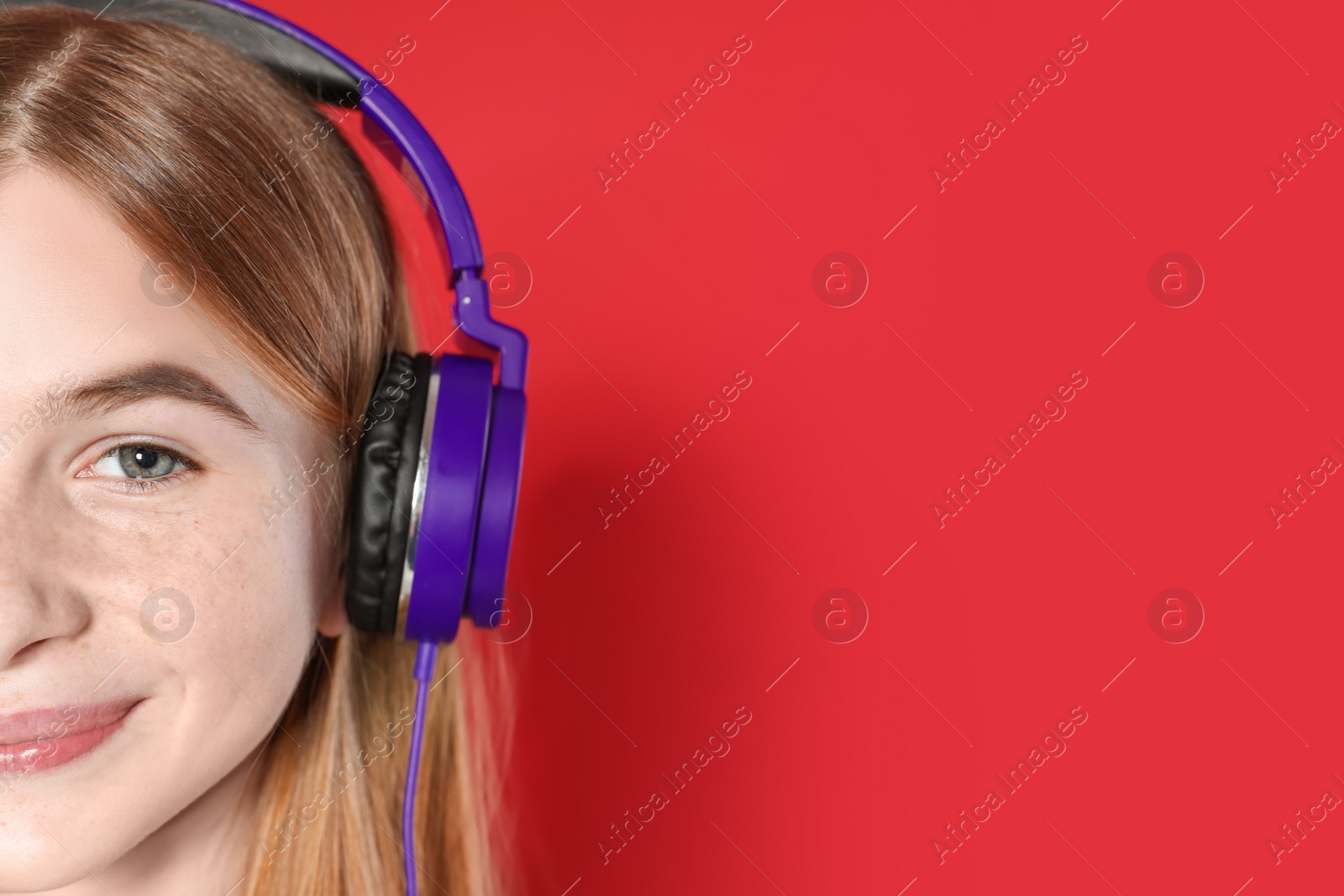 Photo of Teenage girl enjoying music in headphones on color background, closeup. Space for text