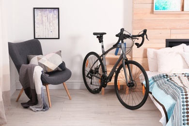 Modern apartment interior with bicycle near bed