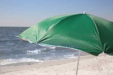 Photo of Green beach umbrella near sea on sunny day