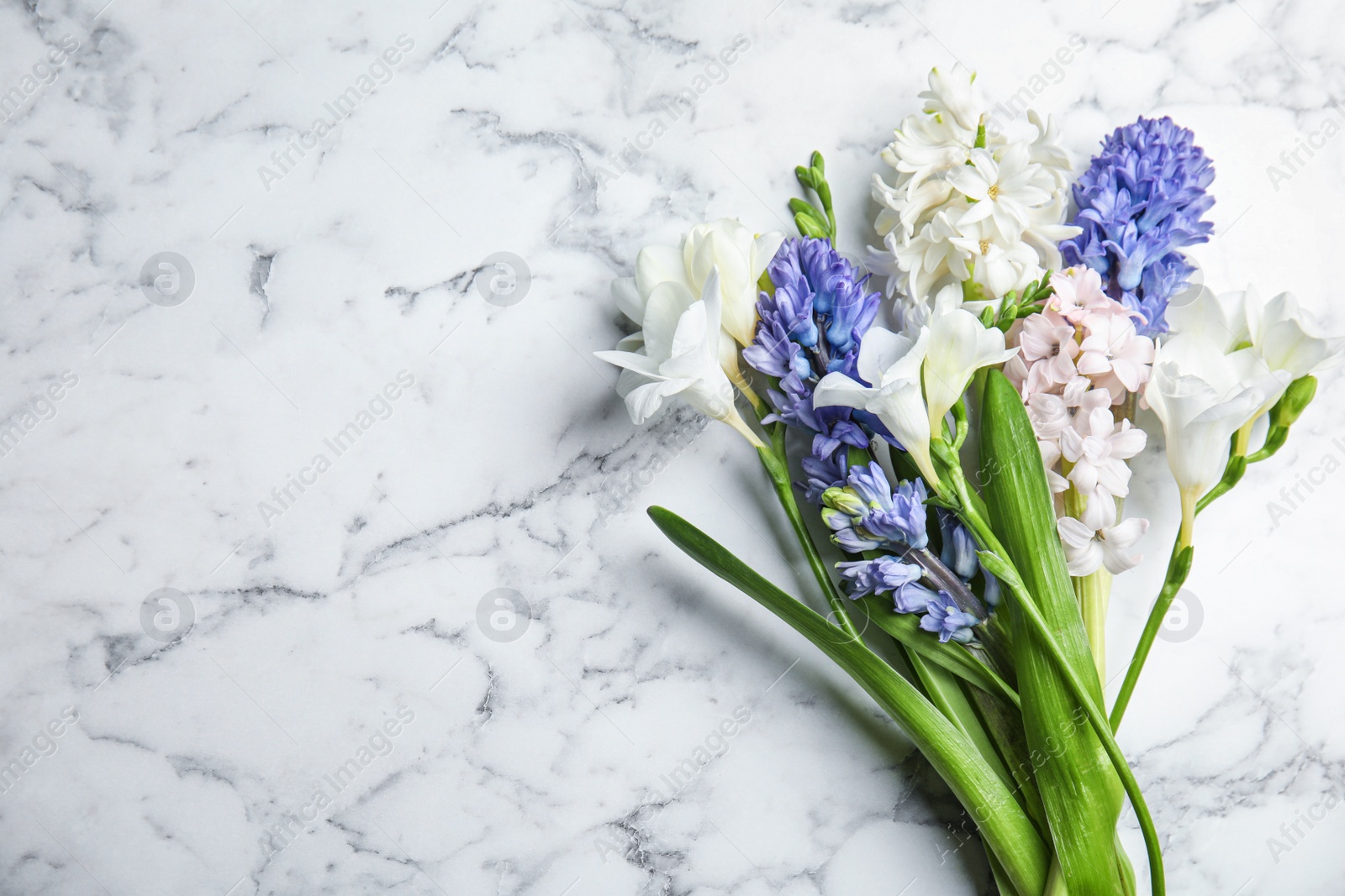 Photo of Beautiful spring flowers on white marble table, flat lay. Space for text