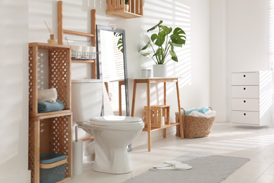 Interior of stylish bathroom with toilet bowl and decor elements