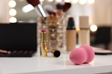 Photo of Makeup Sponge and other beauty products on white table indoors, selective focus