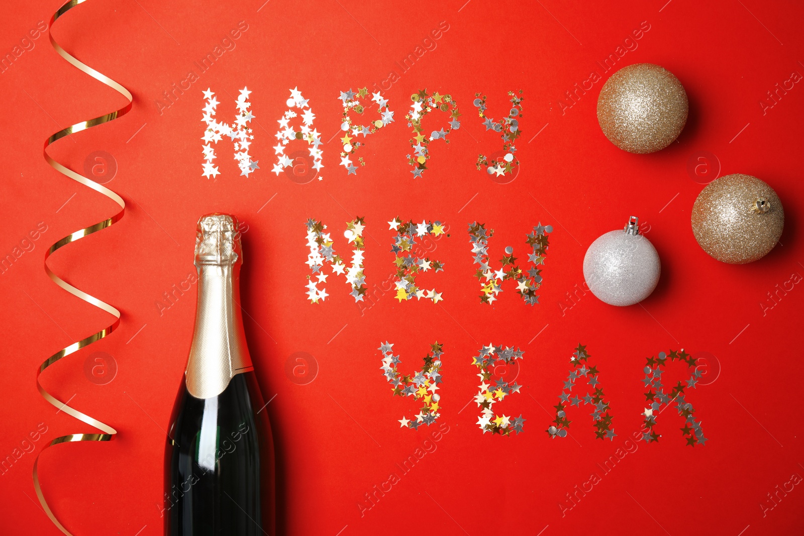 Photo of Creative flat lay composition with bottle of champagne and words HAPPY NEW YEAR on color background