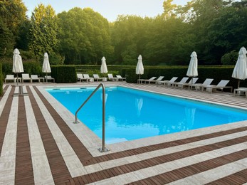 Photo of Outdoor swimming pool in luxury hotel on sunny summer day. Time for relax