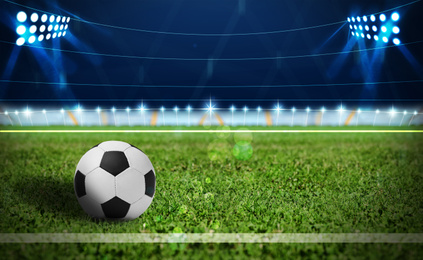 Image of Soccer ball on green football field, space for text 