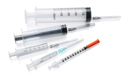 Photo of Different disposable syringes with needles on white background