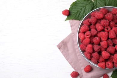 Photo of Delicious fresh ripe raspberries on white wooden table, flat lay. Space for text