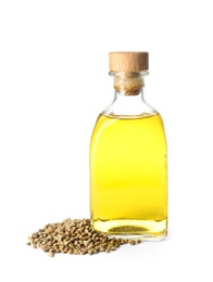 Photo of Bottle with hemp oil and seeds on white background