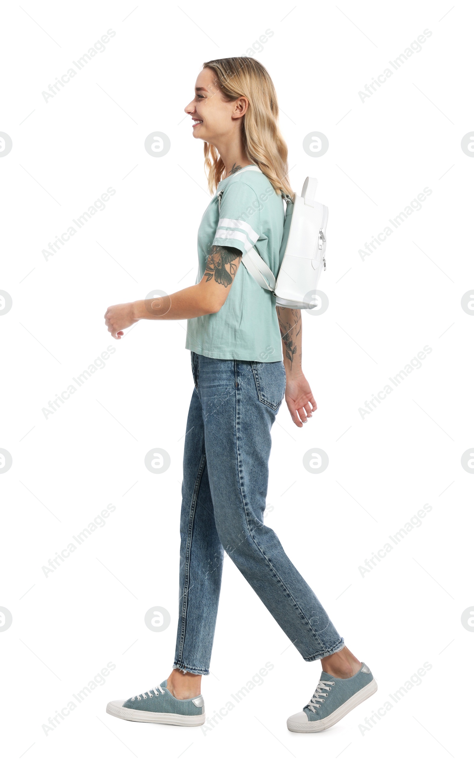 Photo of Beautiful young with backpack woman walking on white background