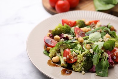 Photo of Tasty salad with balsamic vinegar on light table, closeup