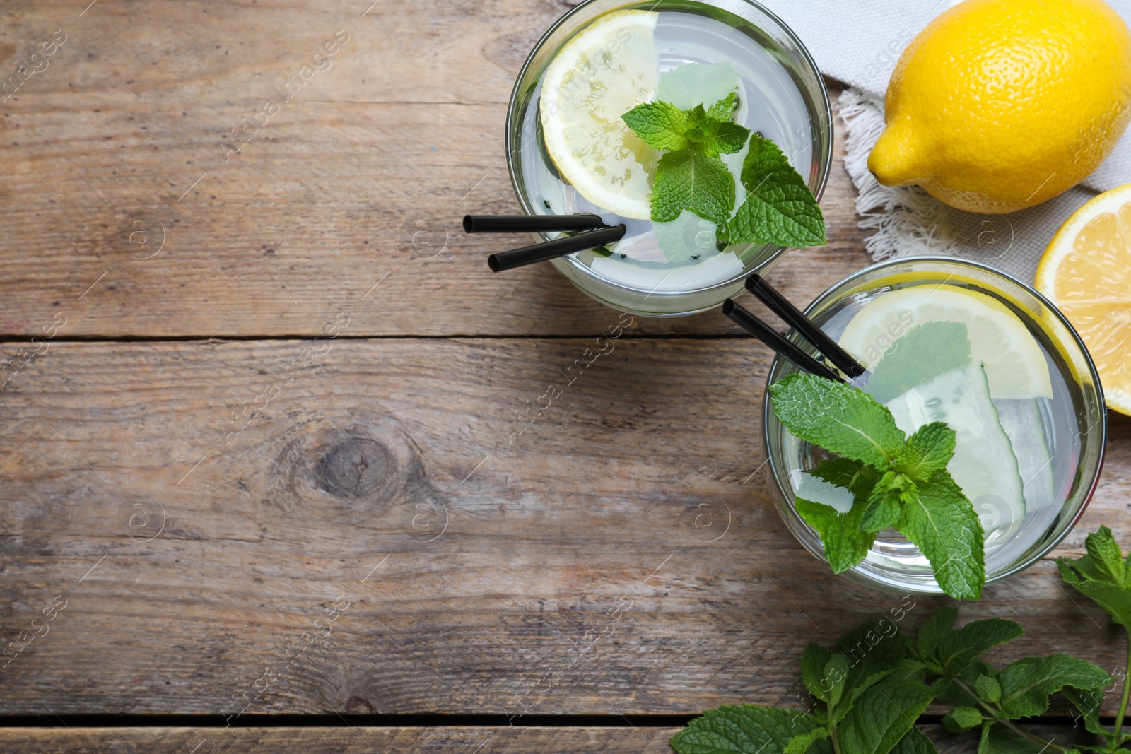 Photo of Refreshing water with cucumber, lemon and mint on wooden table, flat lay. Space for text