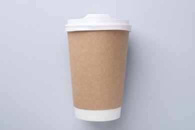 One paper cup on light grey background, top view. Coffee to go