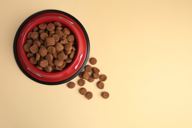 Photo of Dry dog food and feeding bowl on beige background, flat lay. Space for text