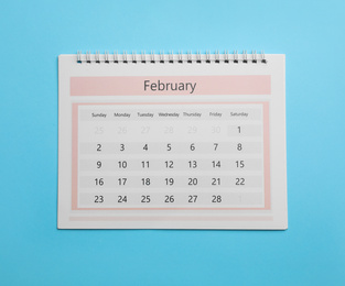 Photo of February calendar on light blue background, top view