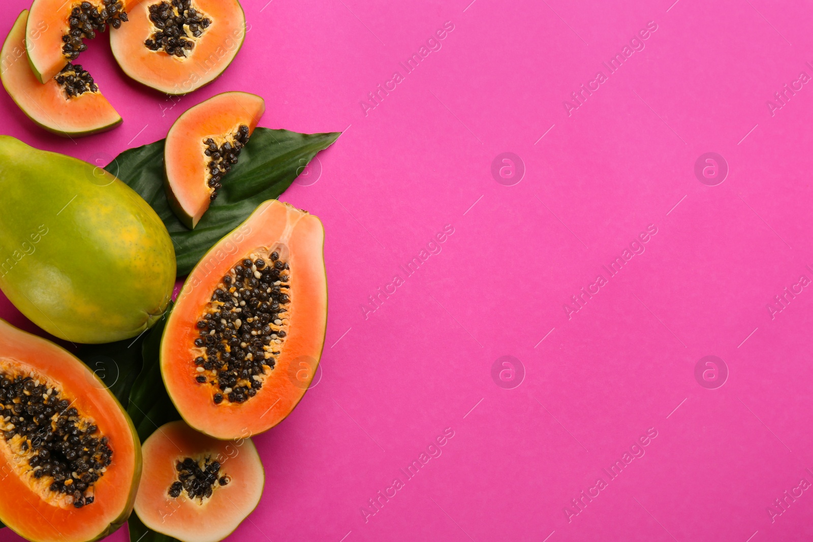 Photo of Fresh ripe papaya fruits with green leaves on purple background, flat lay. Space for text