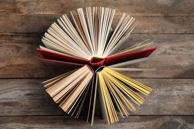 Circle made of hardcover books on wooden background, flat lay