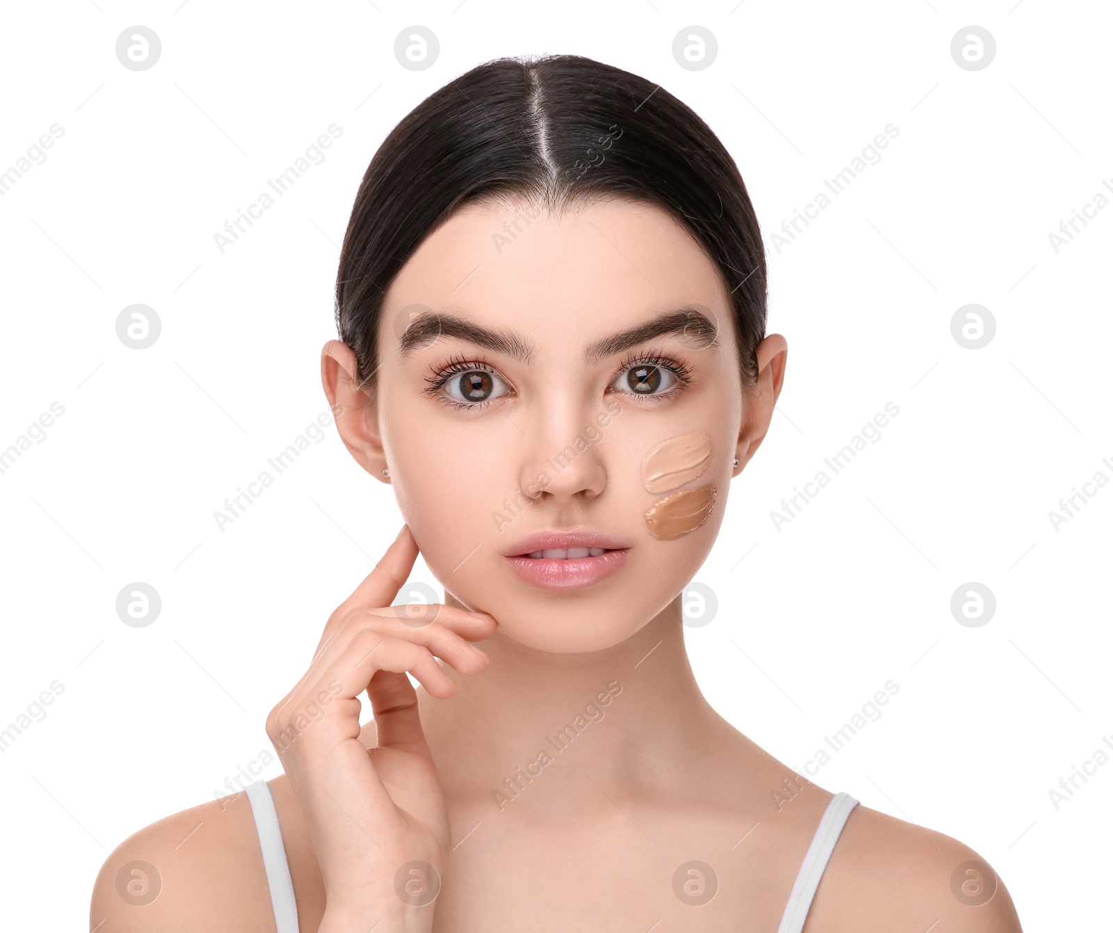 Photo of Teenage girl with swatches of foundation on face against white background