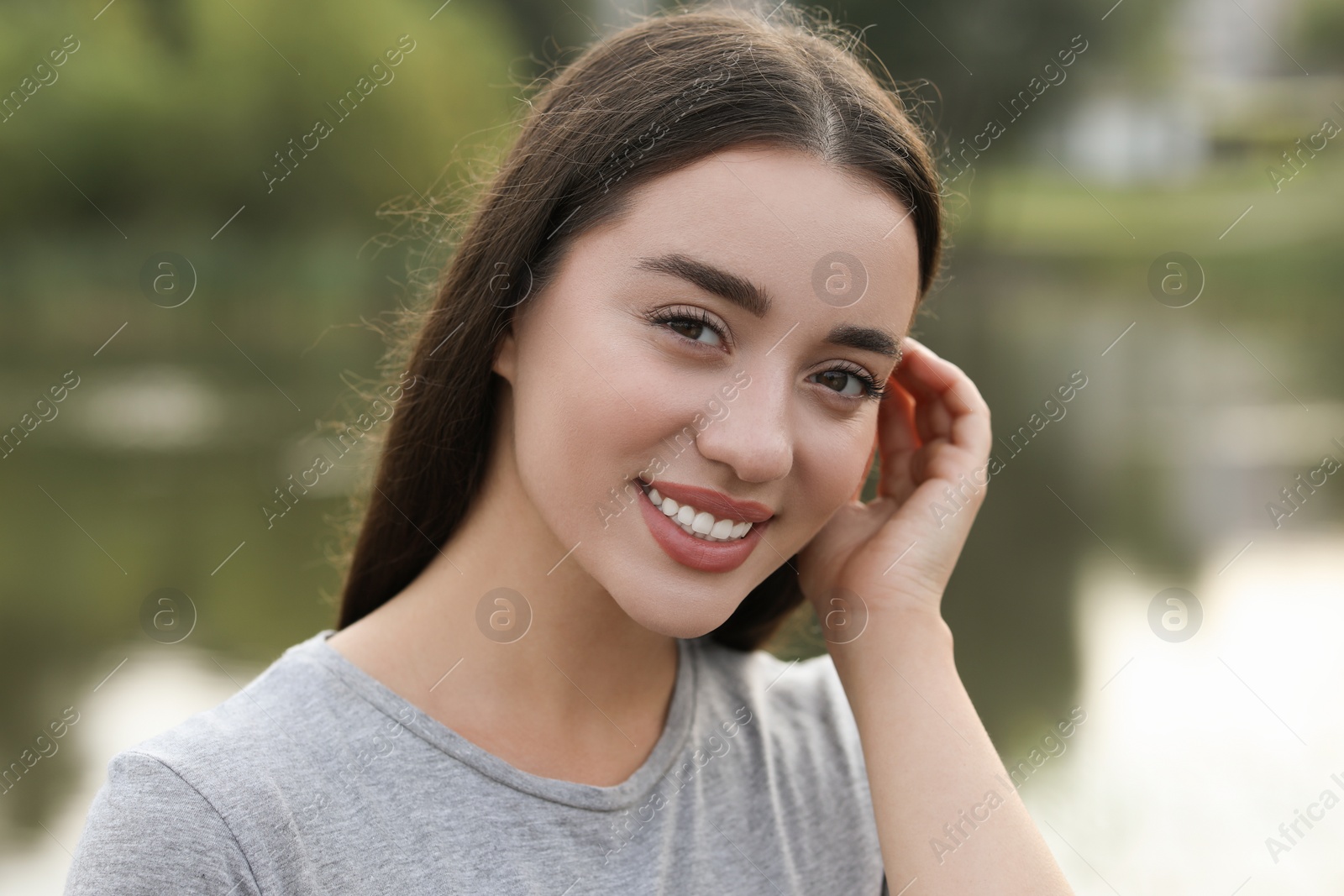 Photo of Portrait of beautiful woman outdoors. Attractive lady smiling and looking into camera