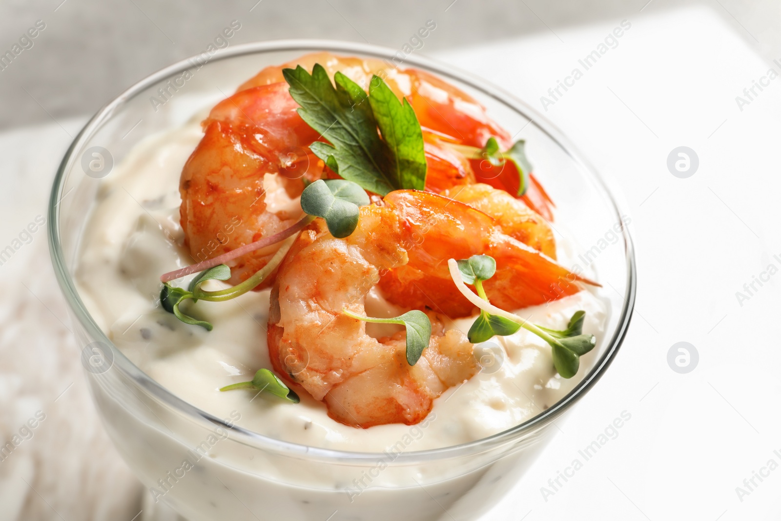 Photo of Bowl with fried shrimps and sauce on light background