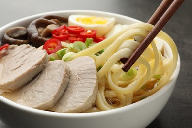 Noodle soup. Eating delicious ramen with chopsticks at table, closeup