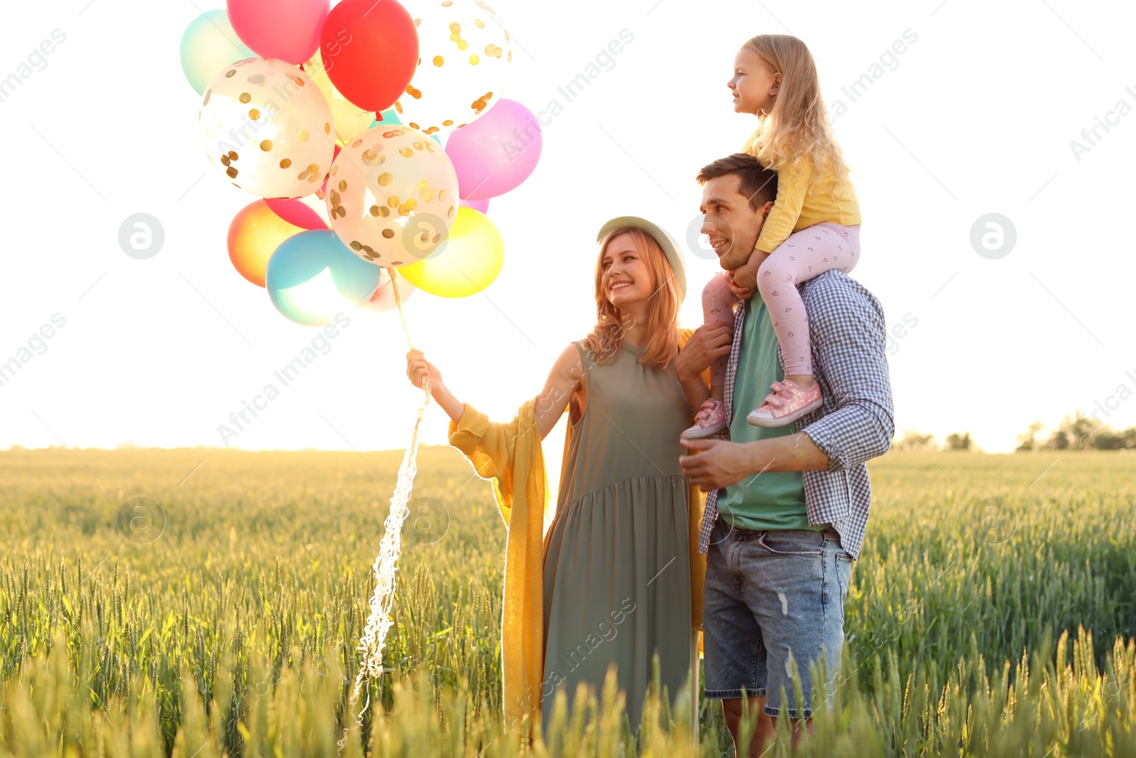 Photo of Happy family with colorful balloons outdoors on sunny day