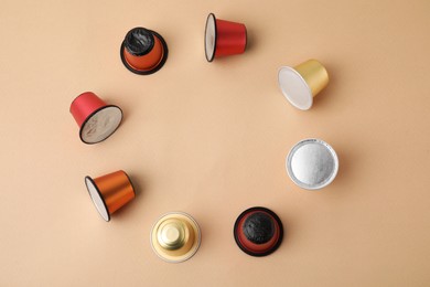 Frame made of many coffee capsules on beige background, top view. Space for text