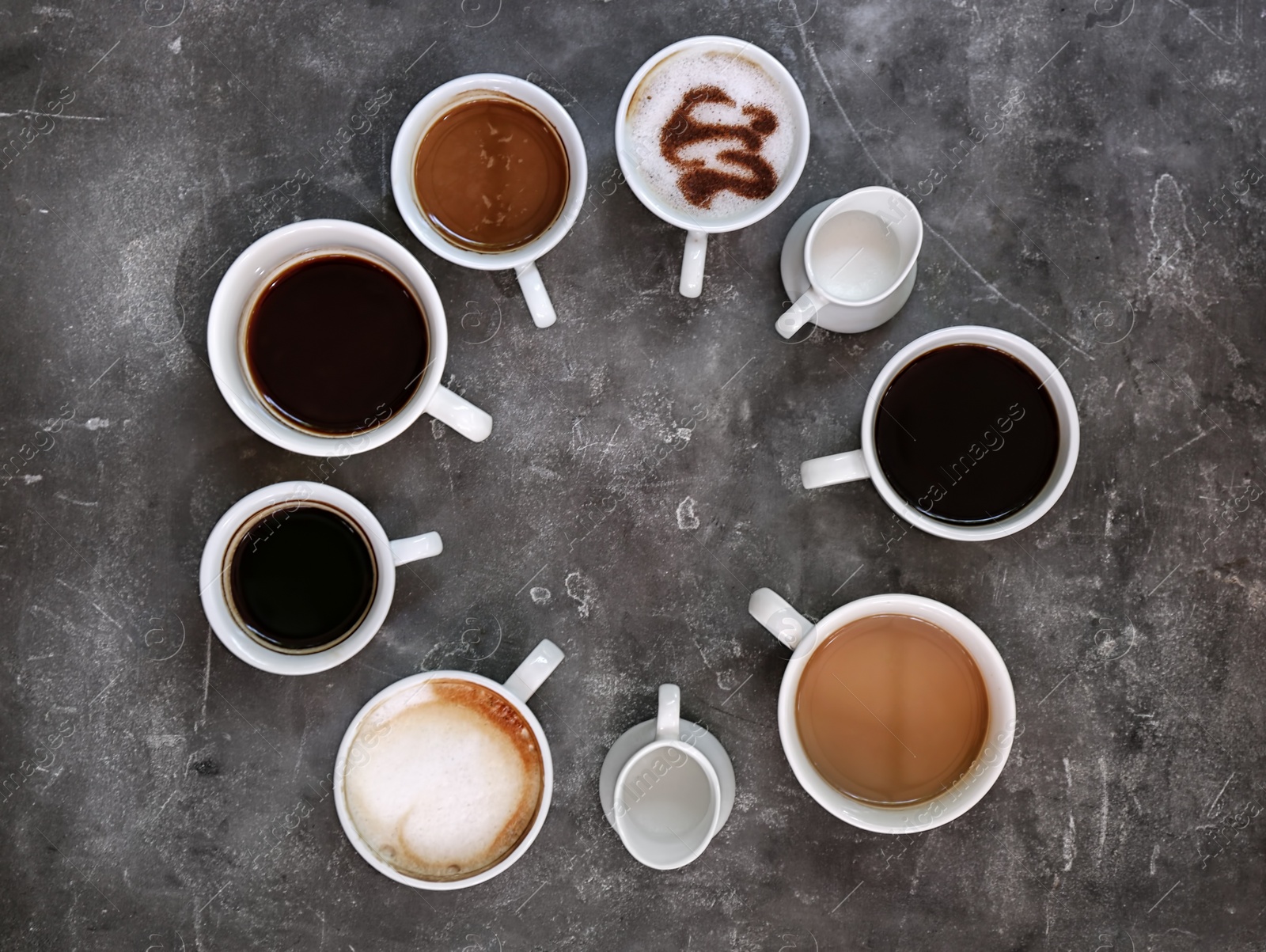 Photo of Cups of fresh aromatic coffee on grey background, top view