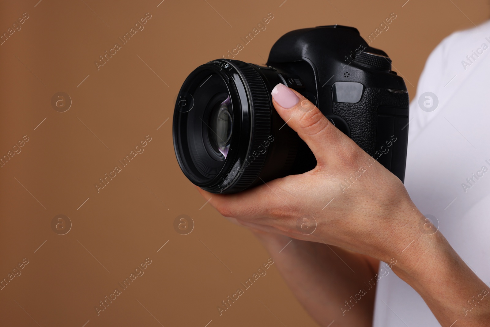 Photo of Photographer with camera on brown background, closeup. Space for text