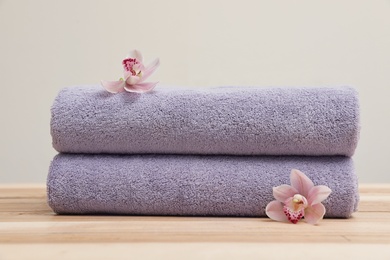 Stack of fresh towels with flowers on table