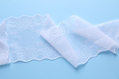 White lace on light blue background, top view