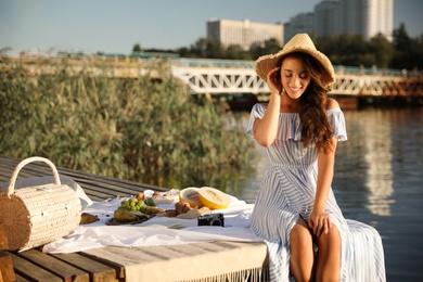 Young woman spending time on pier at picnic