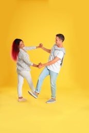 Photo of Beautiful lovely couple dancing on yellow background