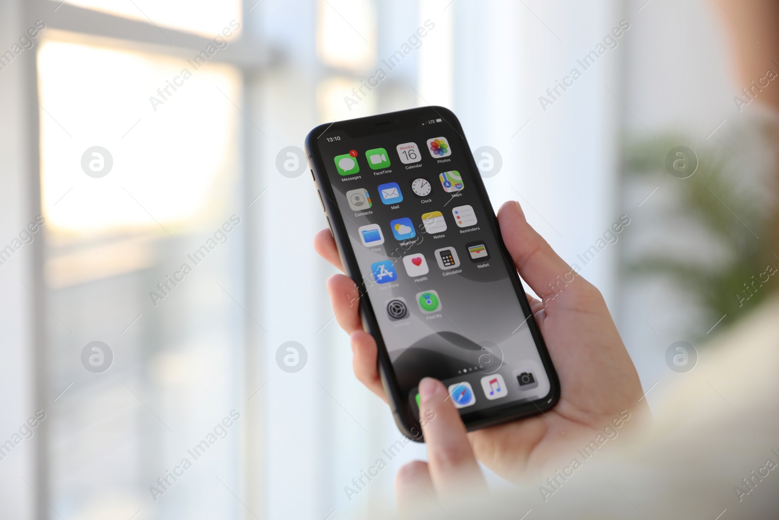 Photo of MYKOLAIV, UKRAINE - MARCH 16, 2020: Woman holding iPhone 11 with home screen indoors, closeup