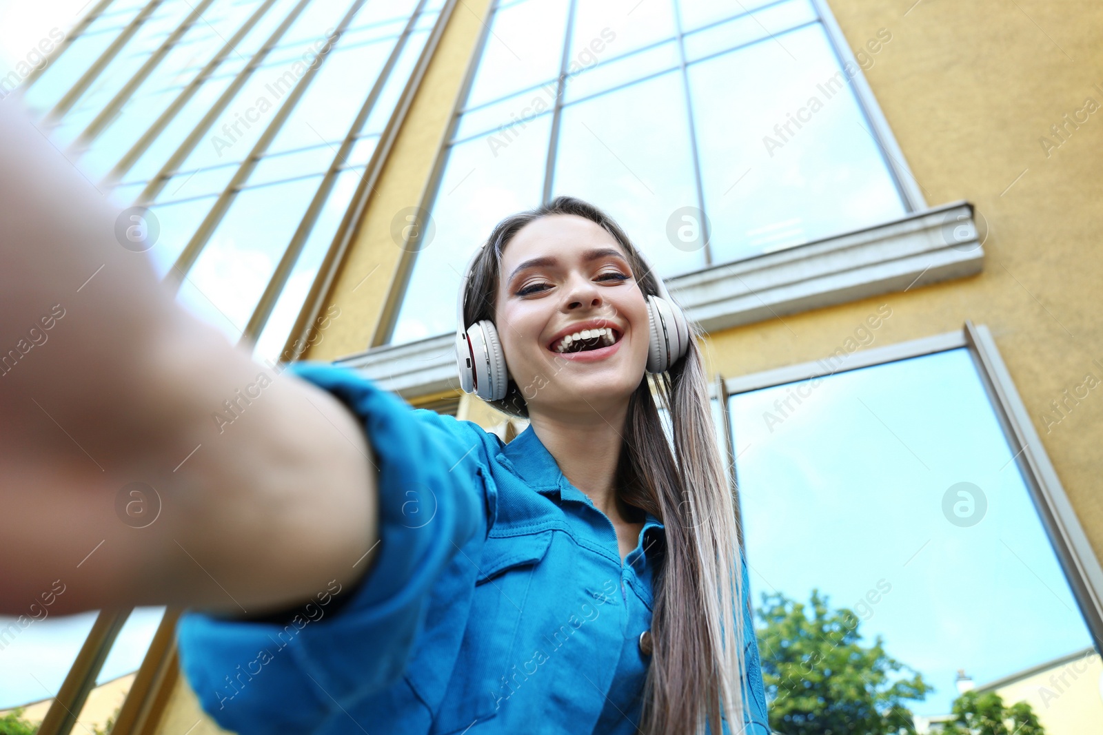 Photo of Happy young woman taking selfie on city street