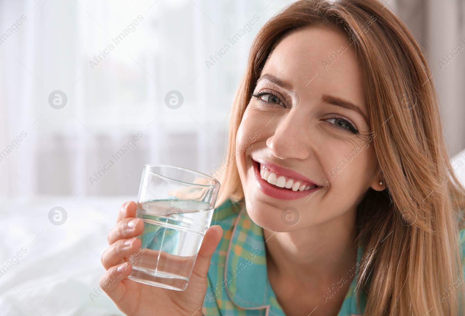 Photo of Young woman with glass of clean water at home