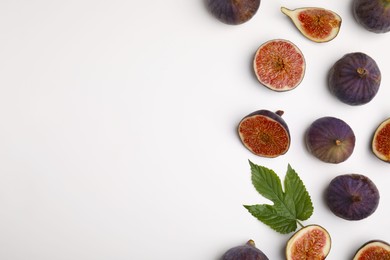 Photo of Fresh ripe figs with green leaf on white background, flat lay. Space for text