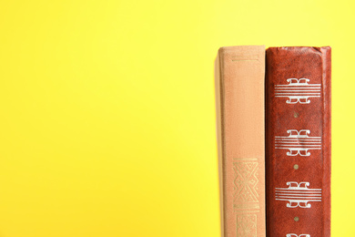 Photo of Old books on yellow background, space for text