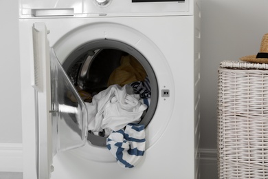 Washing machine with laundry near wall in room
