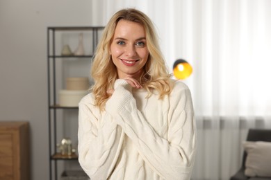 Happy woman in stylish warm sweater at home