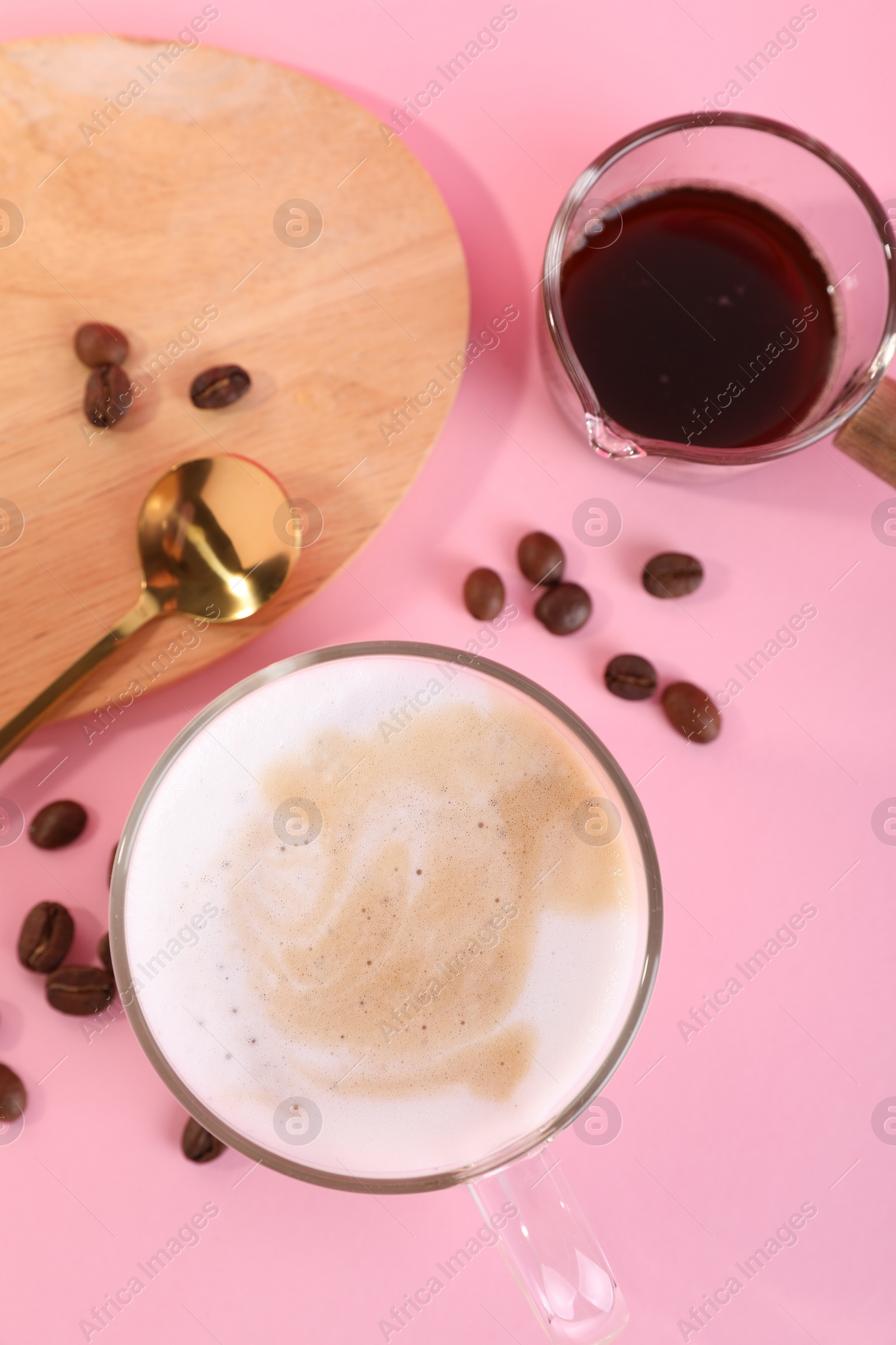 Photo of Cup of fresh coffee and beans on pink table, flat lay